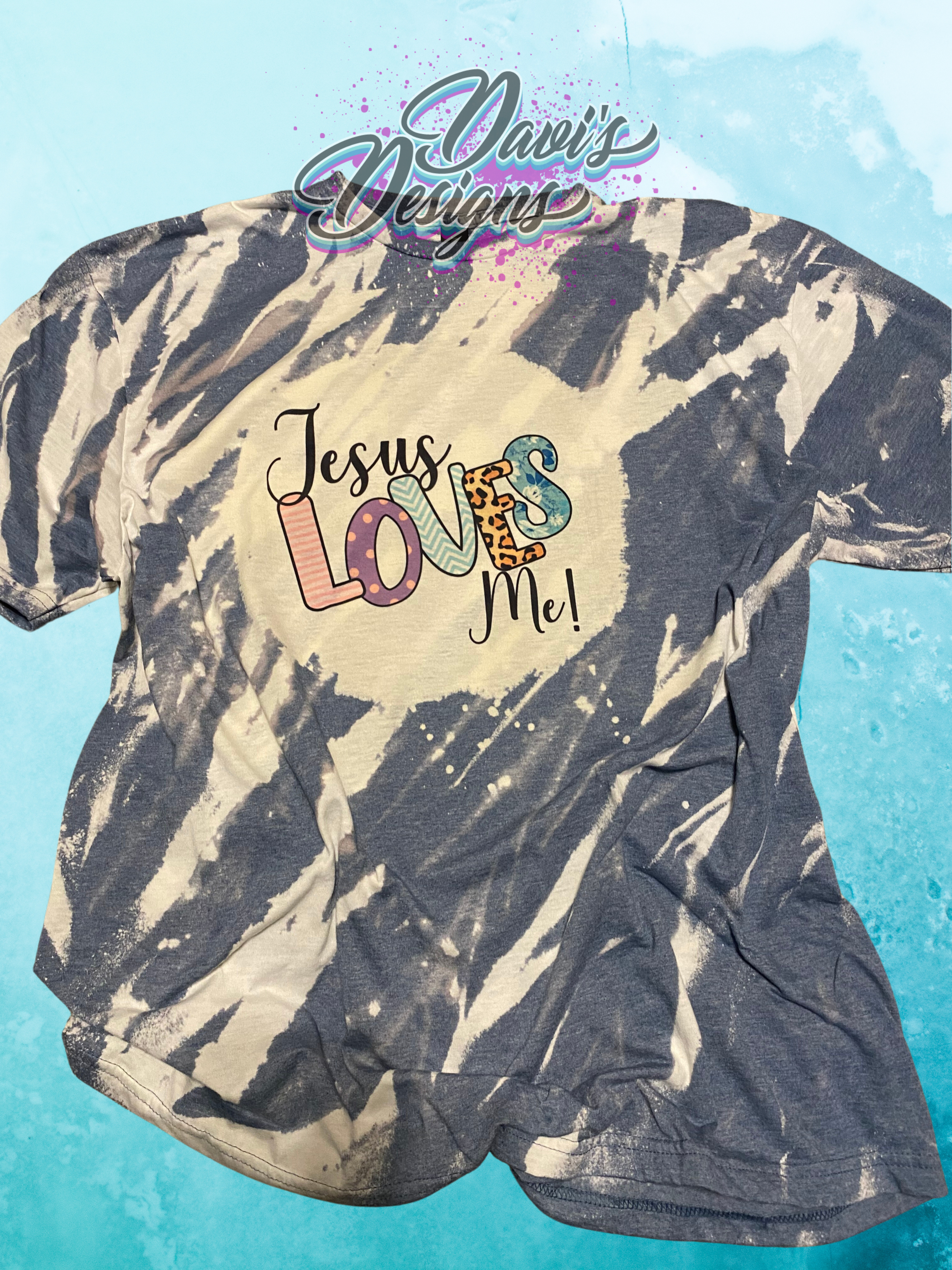 Heather Indigo bleach patterned tee with saying of Jesus Loves Me.